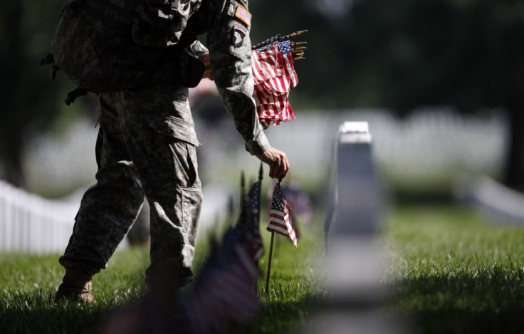A member of the U.S. Army Old Guard places a flag at one of the over 220,000 graves of fallen U.S. military service members buried at Arlington National Cemetery, May 24, 2012.