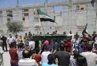 Mourners clap for Yaser Raqieh, who was killed near Hama by forces loyal to regime of Syrian President Bashar al-Assad