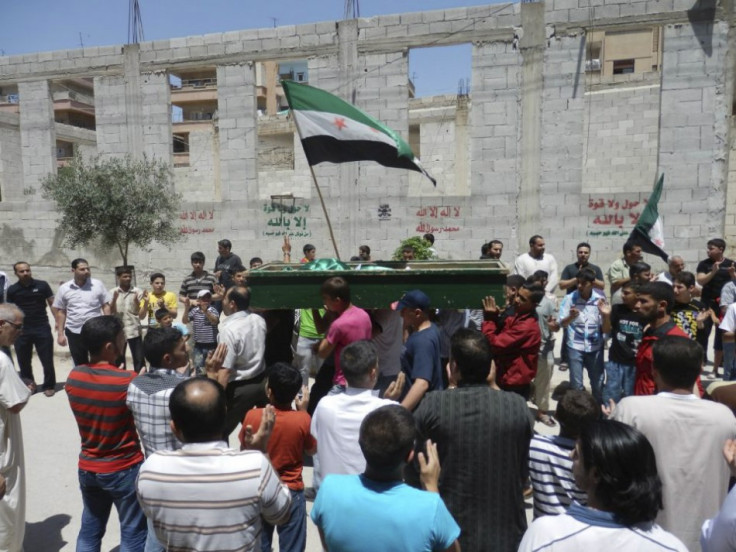 Mourners clap for Yaser Raqieh, who was killed near Hama by forces loyal to regime of Syrian President Bashar al-Assad