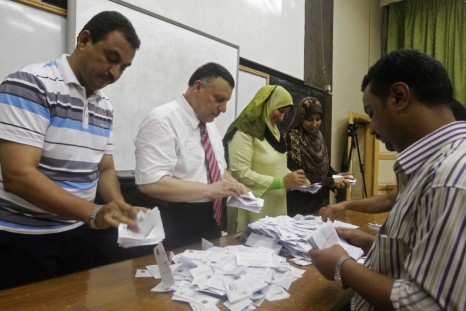 Electoral workers count ballots at polling station in Cairo after polls close in presidential runoff