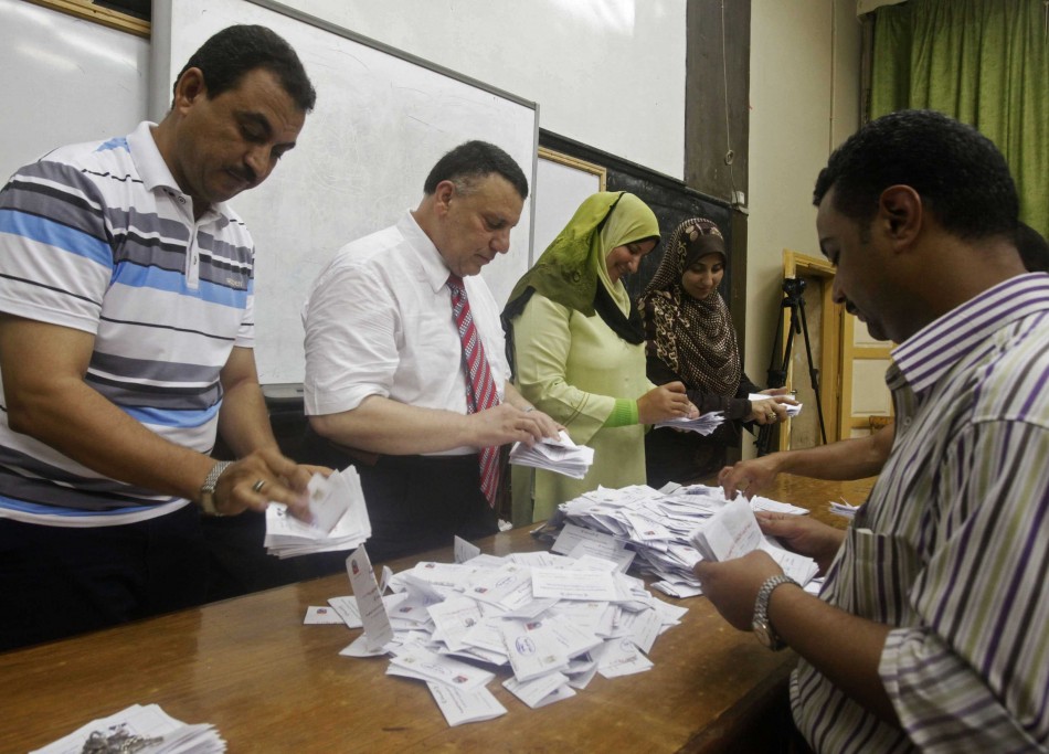 Electoral workers count ballots at polling station in Cairo after polls close in presidential runoff