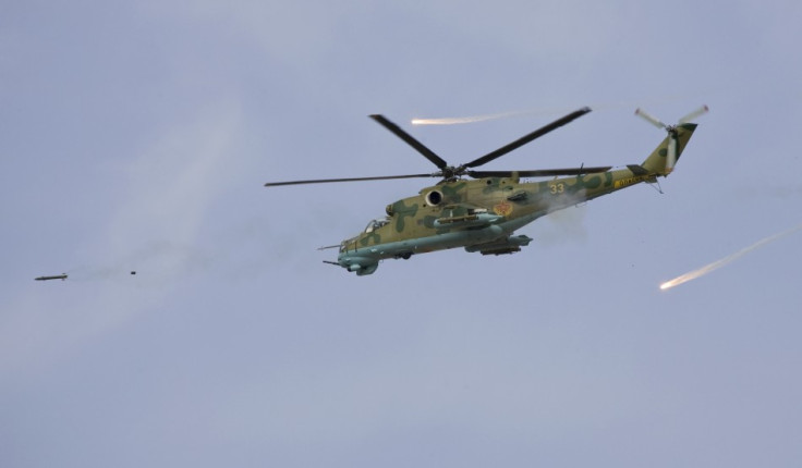 A Russian-made attack helicopter fires a rocket and releases flares
