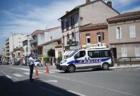 Police block the street at the scene where a man claiming to be a member of al Qaeda has taken four hostages in a bank in Toulouse