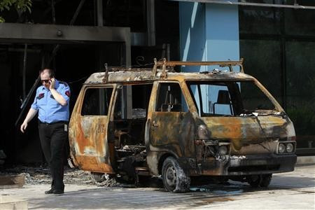 Security guard confers with colleagues by van gutted in attack on Microsoft office in Athens Security guard confers with colleagues by van gutted in attack on Microsoft office in Athens