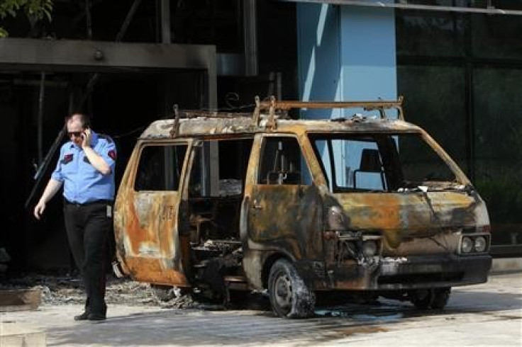Security guard confers with colleagues by van gutted in attack on Microsoft office in Athens