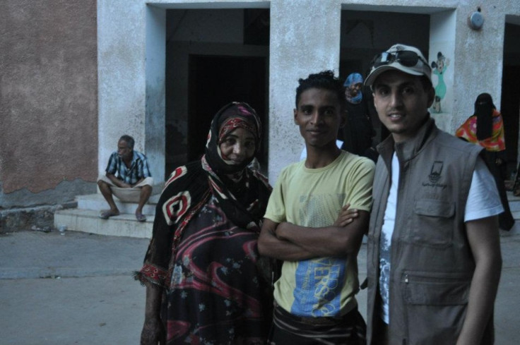 Habib (wearing cap)  is with Majed, 15, and his mother in Aden City, south Yemen. Majed's family is one of more than 28 families who live in this school building as refugees.