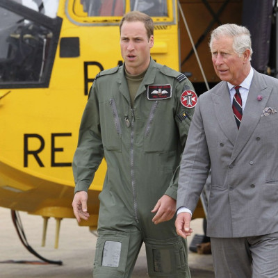Britain&#039;s Prince Charles and his son Prince William walk back to the RAF Rescue base after Prince William showed his father his helicopter at RAF Valley, in Valley, Wales