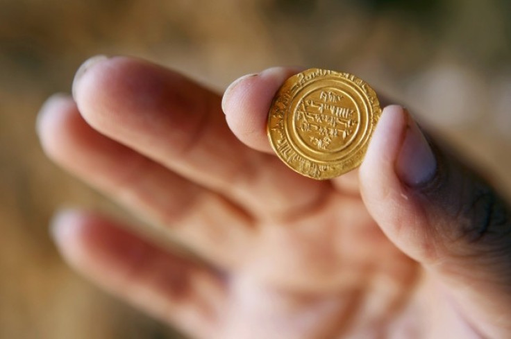 Israel Nature and Parks Authority employee holds up a gold coin, which was unearthed during excavations at a Crusader fortress near Herzliya. (Photo: REUTERS)