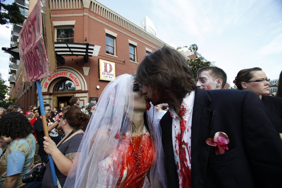 A couple dressed up as zombies kisses during a zombie walk during the Comic Con International convention in San Diego