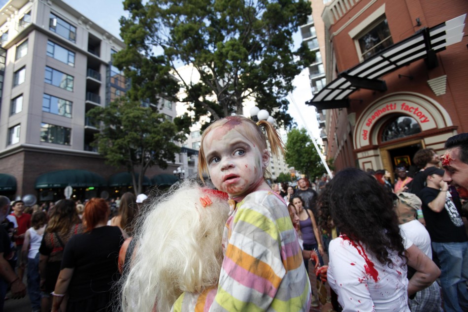 A young girl dressed up as a zombie takes part in a zombie walk during the Comic Con International convention in San Diego