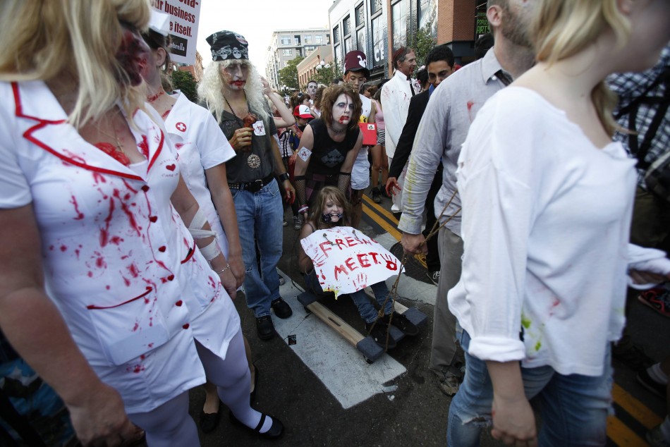 People dressed up as zombies take part in a zombie walk during the Comic Con International convention in San Diego