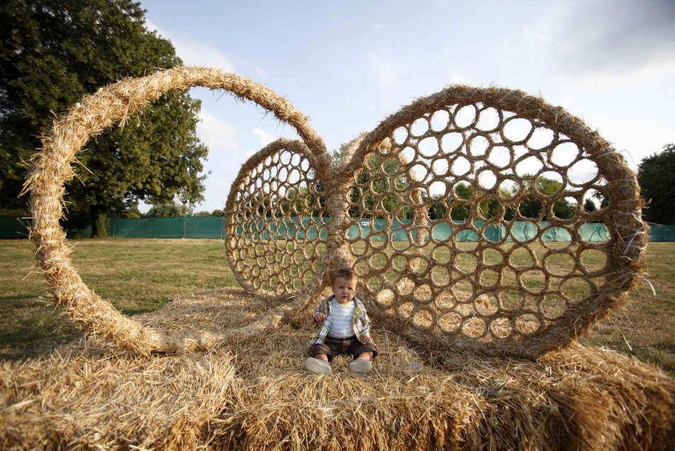 A child sits in a straw art installation during the 7th Straw - Land Art Festival in Osijek