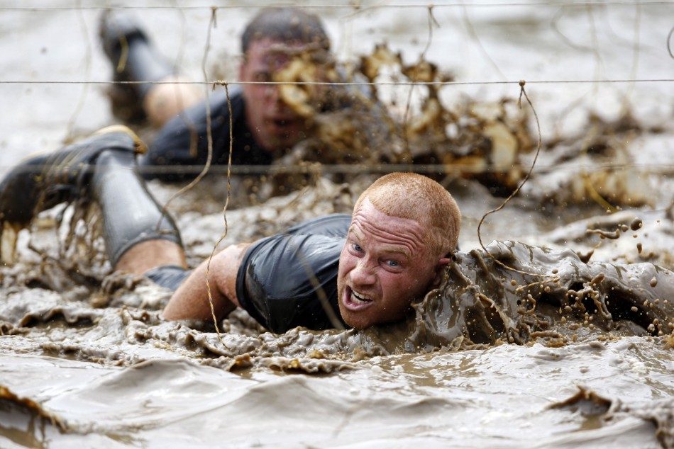 Competitors swim through mud underneath electrified wires during the Tough Mudder at Mt. Snow in West Dover