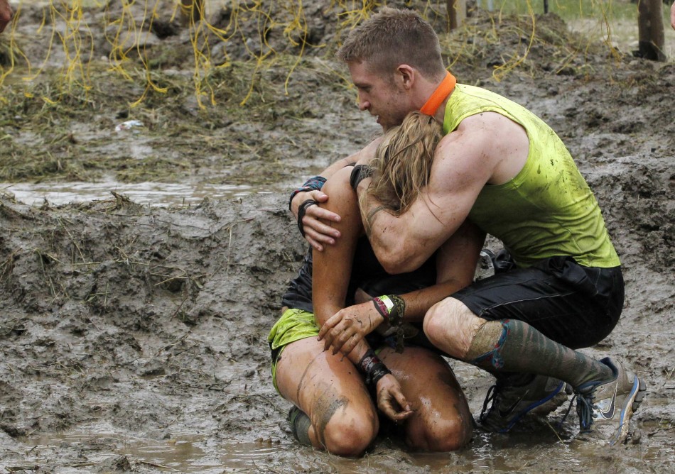 A competitor comforts his teammate after she made it through the last obstacle during the Tough Mudder at Mt. Snow in West Dover