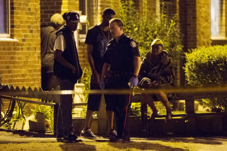 Police survey a crime scene following a shooting in Scarborough, a suburb in east Toronto