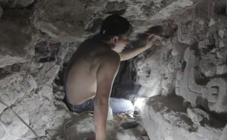 An archaeologist cleans the stucco that depicts several phases of sun at the ancient Mayan temple site in Guatemala. (Photo: Video Screenshot, Brown University)