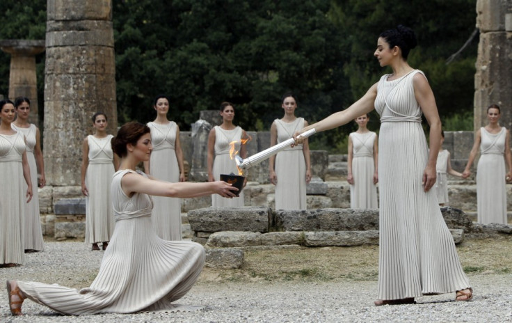 Menegaki (R), playing the role of High Priestess, lights the Olympic flame during the torch lighting ceremony of the London 2012 Olympic Games at the site of ancient Olympia in Greece May 10, 2012. (Photo: Reuters)