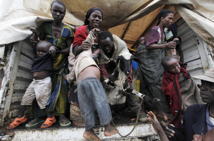Refugees from Democratic Republic of Congo jump from a UNHCR at Nyakabande refugee transit camp in Kisoro town (Reuters)