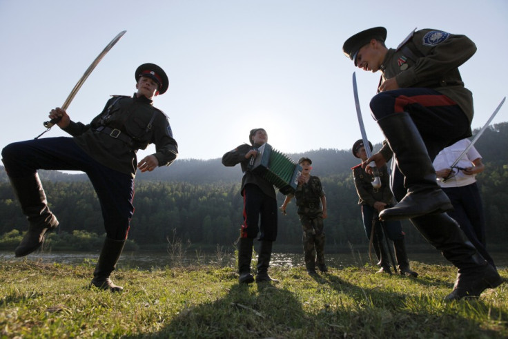 Russian Cossacks perform traditional dance with sabres during annual Mansky tourist three-day-long festival near Mana river in Siberian Taiga, Reuters