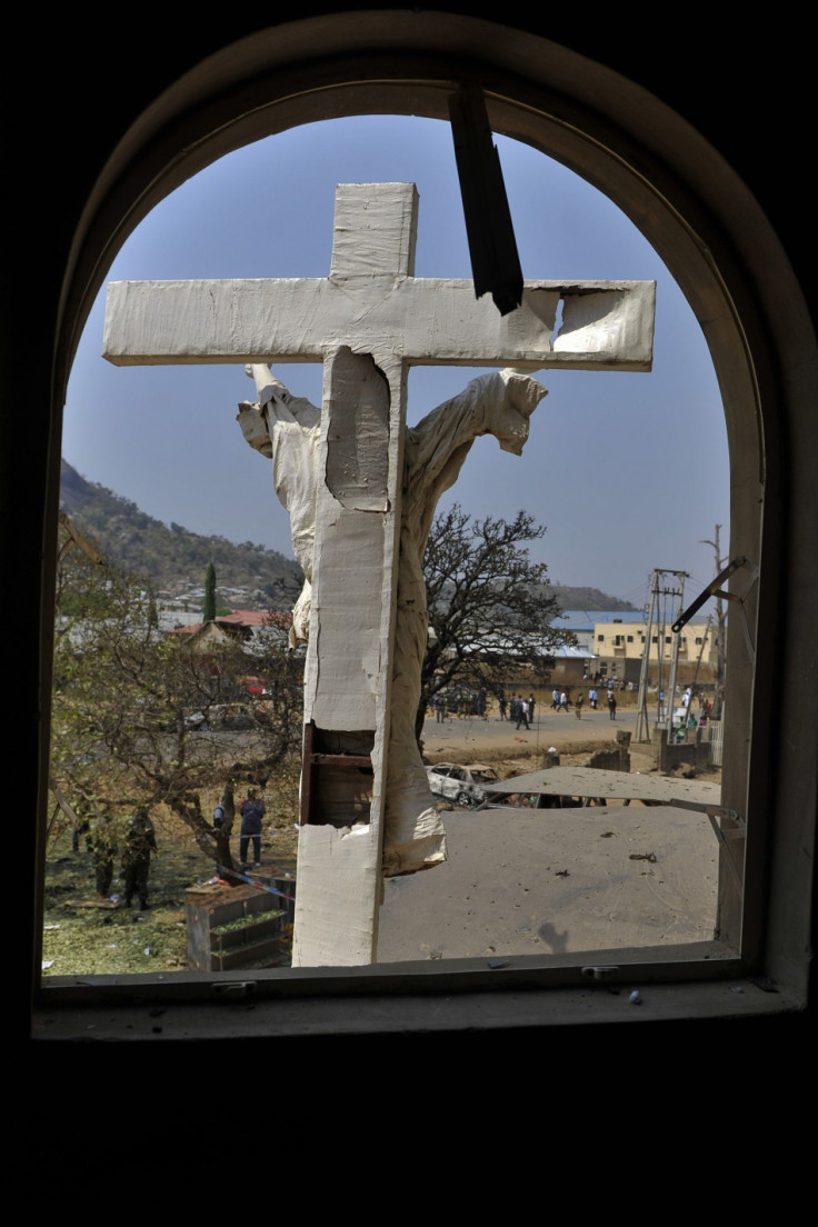 A damaged crucifix overlooks the scene of a bomb explosion at St. Theresa Catholic Church at Madalla