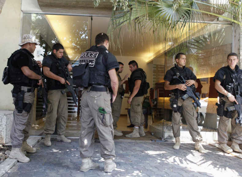 Lebanese policemen stand guard at entrance of building where former Lebanese government minister Samaha lives in Beirut