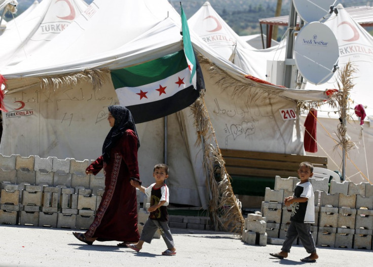 A Syrian refugee woman walks with children at the Boynuyogun refugee camp in Hatay province on the Turkish-Syrian border, Reuters