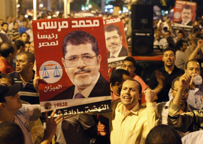 Supporters of Egypt's President Mohamed Mursi chant while carrying posters of him in front of the presidential palace in Cairo