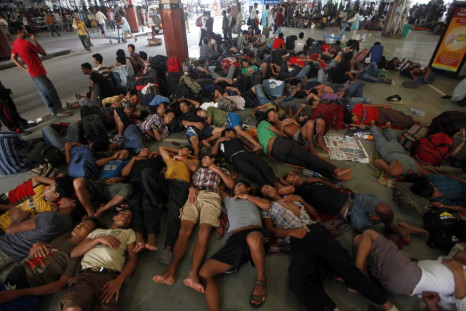 People from India's northeastern states rest while waiting for the train bound for the Assam state at a railway station in Kolkata