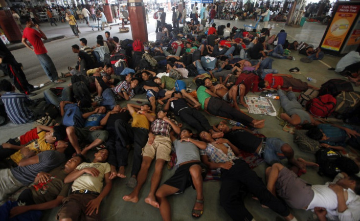 People from India's northeastern states rest while waiting for the train bound for the Assam state at a railway station in Kolkata
