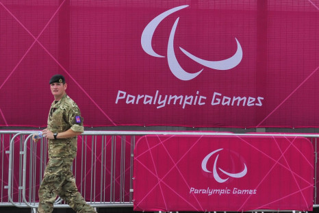 A member of the British army walks past a perimeter fence at the Olympic Park in Stratford