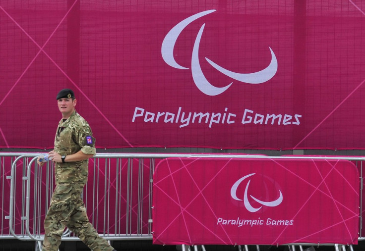 A member of the British army walks past a perimeter fence at the Olympic Park in Stratford