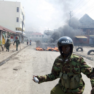 A policeman prepares to lobe a tear-gas canister in the direction of protesting youths in the coastal town of Mombasa