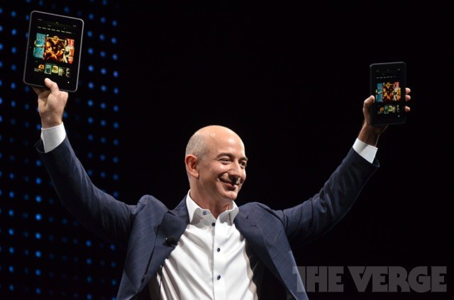 Amazon CEO Jeff Bezos holding up the two versions of the Kindle Fire HD