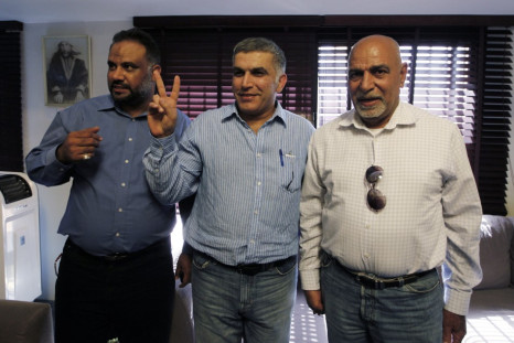 Bahrain human rights activist Nabeel Rajab flashes a victory sign as he poses for photographers with his family members