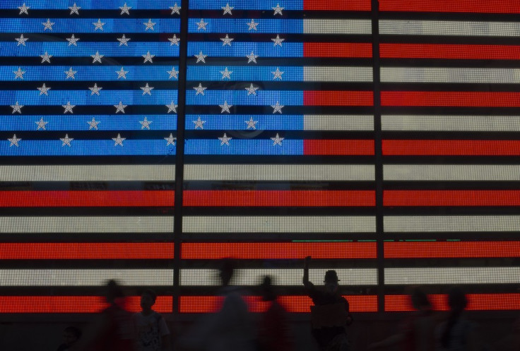 An Occupy Wall Street movement activist raises his fist while protesting in front of a digital flag of the United States