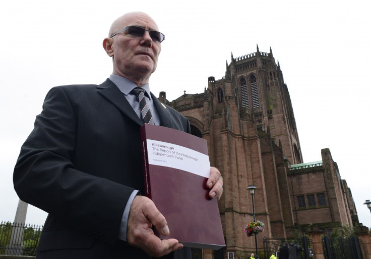 Steve Kelly of the Hillsborough Justice Campaign poses for members of the media with a copy of the independent report into the 1989 Hillsborough Disaster (Reuters)