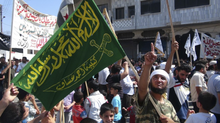 A member of the Free Syrian Army holds a flag during a protest against Syria's President Bashar al-Assad