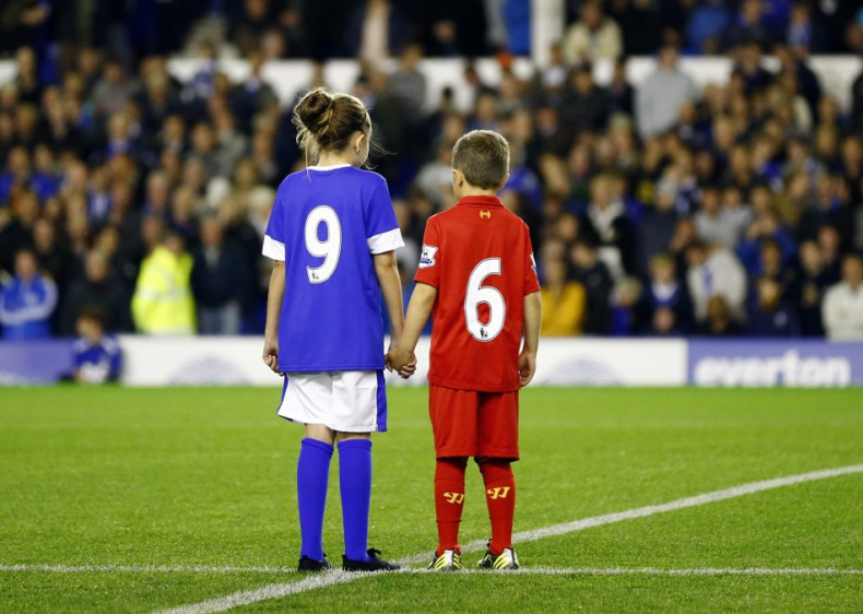 Children wearing Everton and Liverpool shirts pay their respects to the 96 victims of the Hillsborough disaster (Reuters)