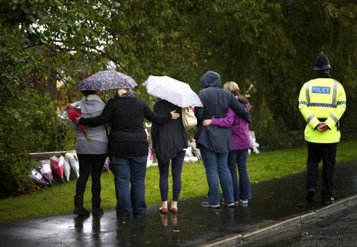 Women embrace before laying floral tributes close to where police constables Fiona Bone and Nicola Hughes were killed in Hattersley (Reuters)