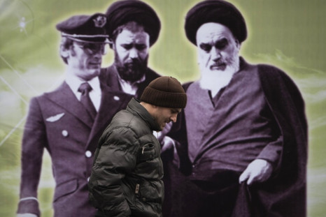 An Iranian man walks past a banner with an image of Iran's late leader Ayatollah Ruhollah Khomeini