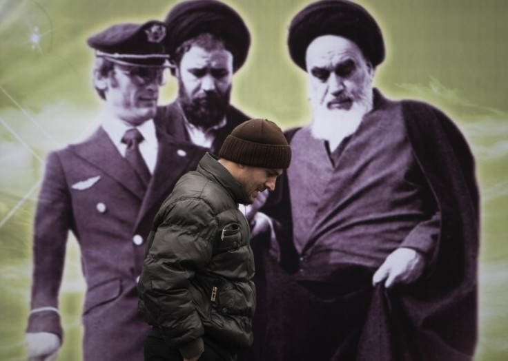 An Iranian man walks past a banner with an image of Iran's late leader Ayatollah Ruhollah Khomeini