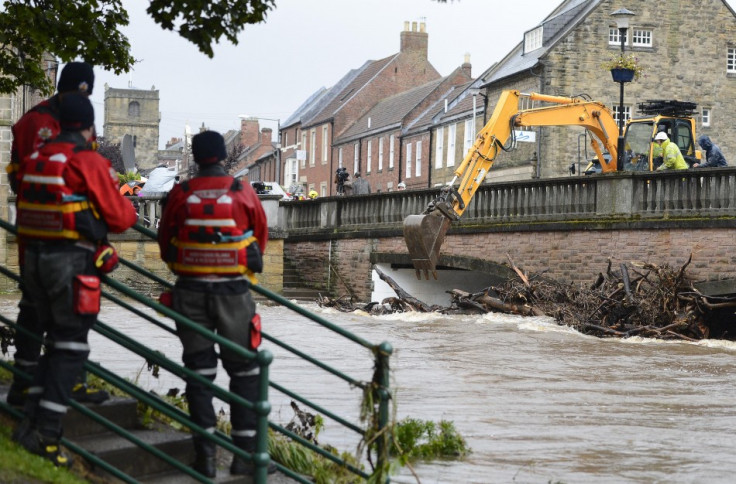 Debris is cleared from a bridge following flooding in Morpeth (Reuters)