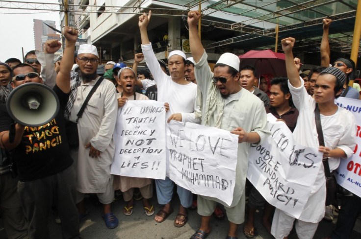 Muslim protesters clench their fists during a protest