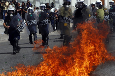 A molotov cocktail explodes beside riot police officers near Syntagma square during a 24-hour labour strike in Athens