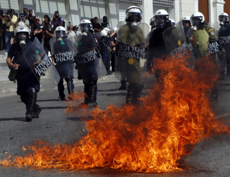 A molotov cocktail explodes beside riot police officers near Syntagma square during a 24-hour labour strike in Athens