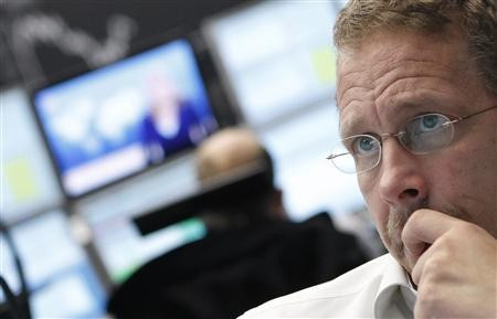 Trader reacts at his desk in front of the DAX board at the Frankfurt stock exchange