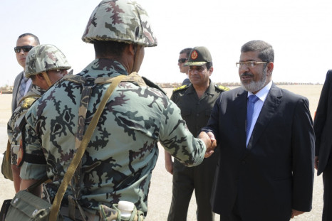 Egypt's President Mursi and Defence Minister Sisi greet soldiers