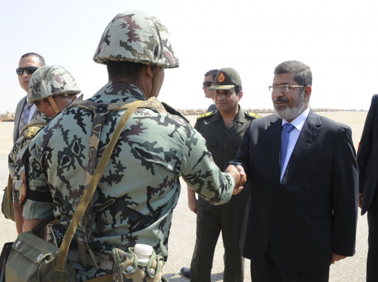Egypt's President Mursi and Defence Minister Sisi greet soldiers