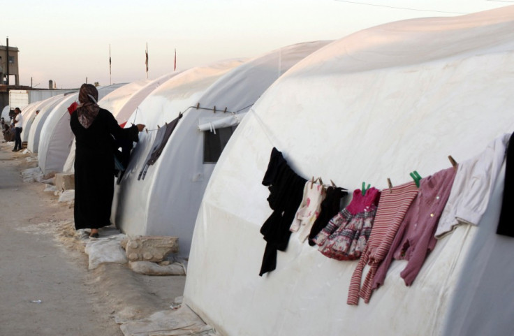 A Syrian refugee hangs her washings on a tent at a refugee camp on the outskirts of Azaz town