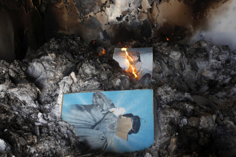People burn pictures of Libyan leader Gaddafi inside the main prison of Gaddafi's forces in Benghazi
